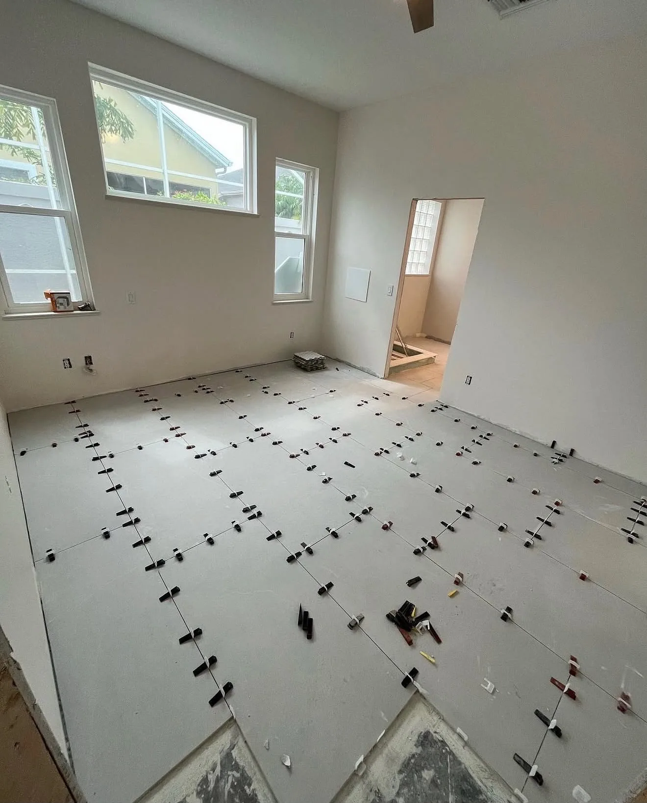 Wide angle of bedroom floor tile setting near the windows