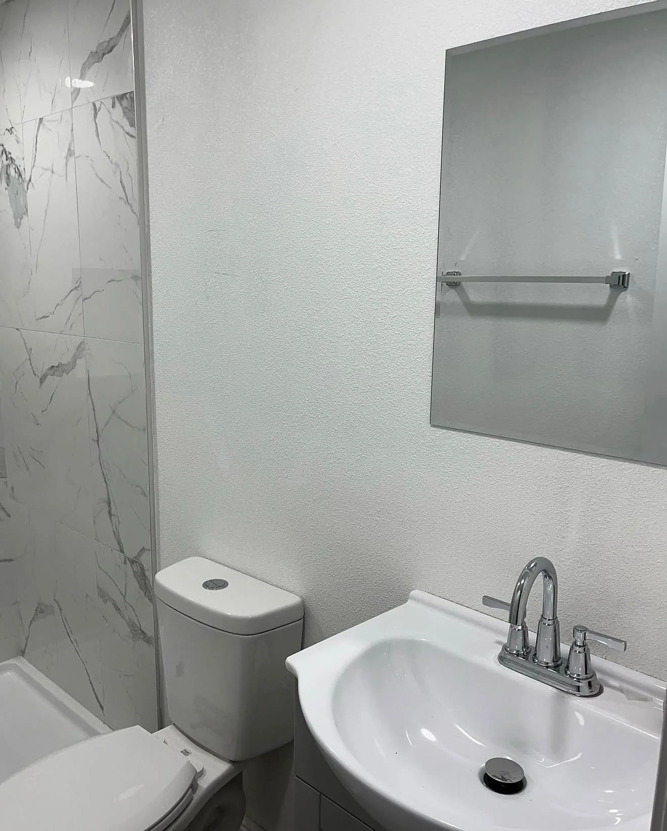 Vanity sink, toilet and mirror with chrome towel bar